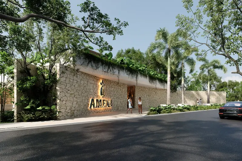 Fachada de piedra con el letrero de Amena y calle arbolada