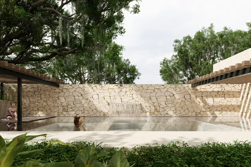 Alberca del Wellness Club con cascada y muro de piedra